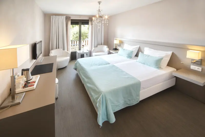 Une chambre lumineuse avec un grand lit et un coin salon.