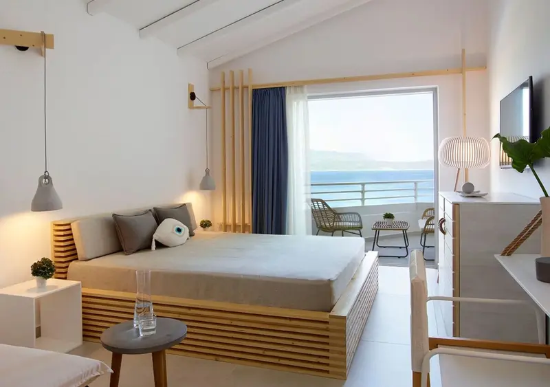 Une chambre lumineuse avec un grand lit et une vue sur la mer.