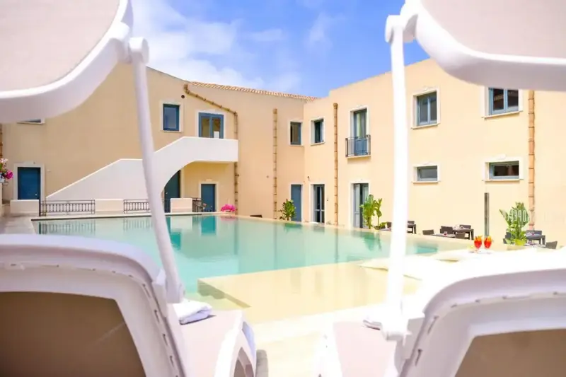 Transats blancs au bord d'une piscine turquoise dans un espace extérieur ensoleillé.
