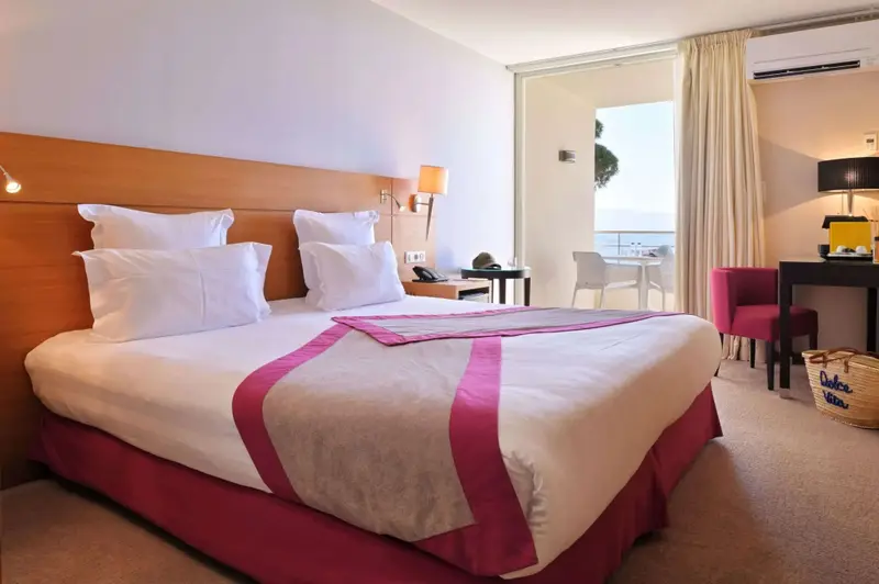 Une chambre lumineuse avec un grand lit et un accès à une terrasse.