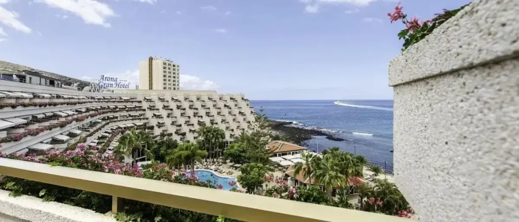Vue d'un complexe hôtelier en terrasses surplombant la mer et une piscine.