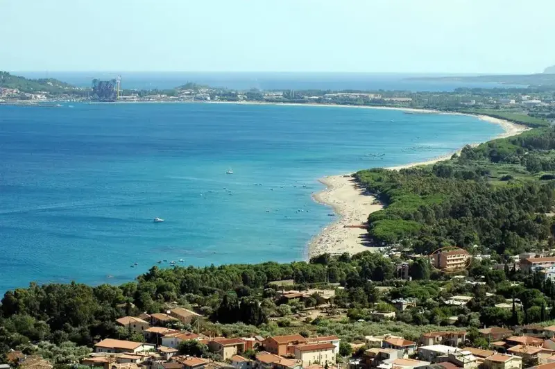 Vue aérienne d'une côte avec une plage de sable et une mer bleue.