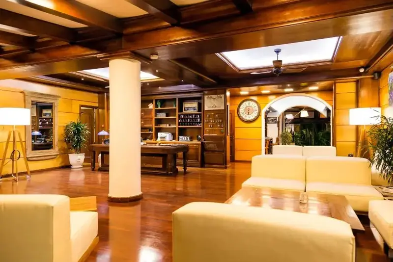 Un espace d'accueil lumineux avec des canapés et un comptoir de réception en fond.