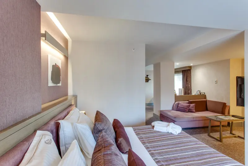 Une chambre spacieuse avec un grand lit et un coin salon confortable.