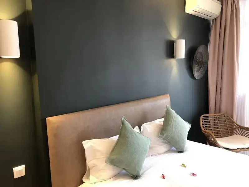Un lit confortable avec des oreillers dans une chambre aux murs sombres.