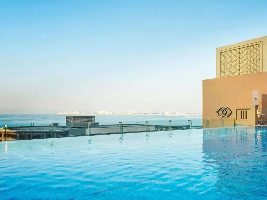 Une piscine à débordement offre une vue sur la mer et la ville.