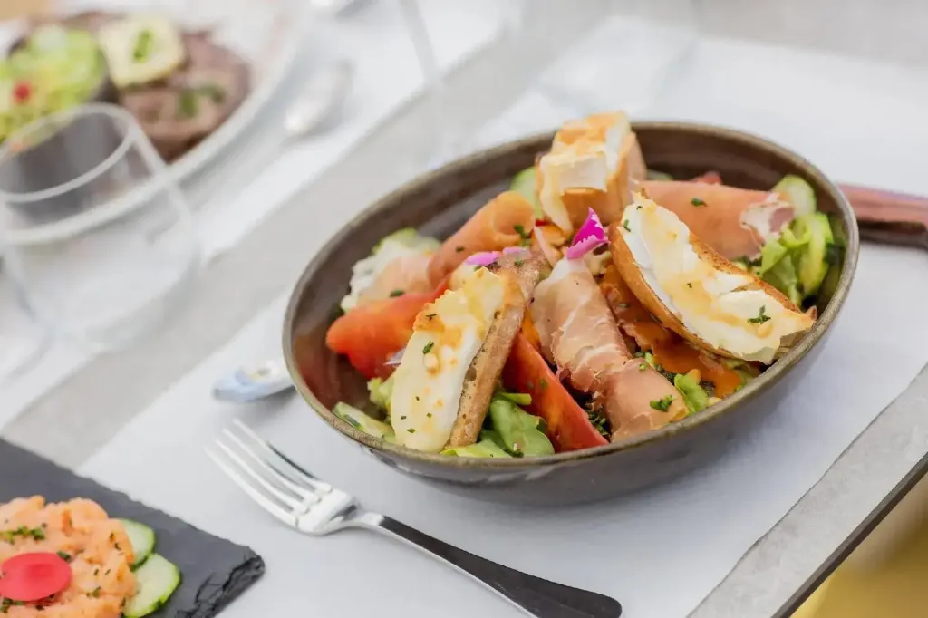 Une salade colorée est présentée sur une table.
