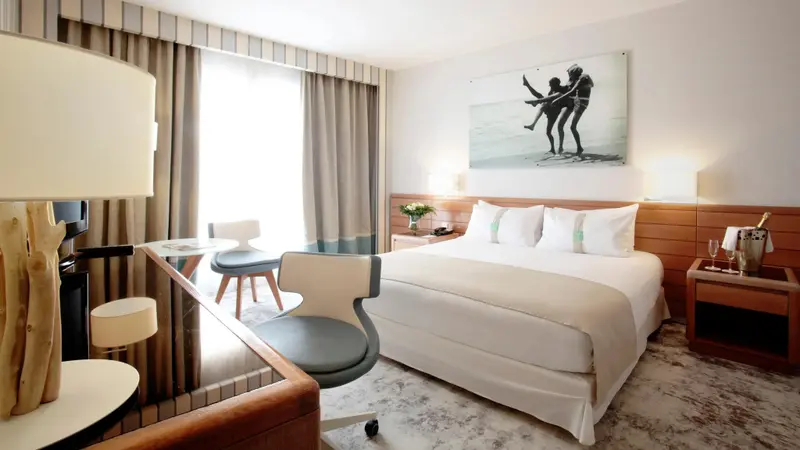 Une chambre lumineuse avec un grand lit et un espace bureau.