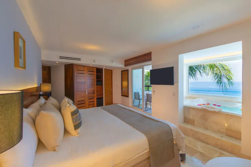 Une chambre lumineuse avec un grand lit et une vue sur la mer.