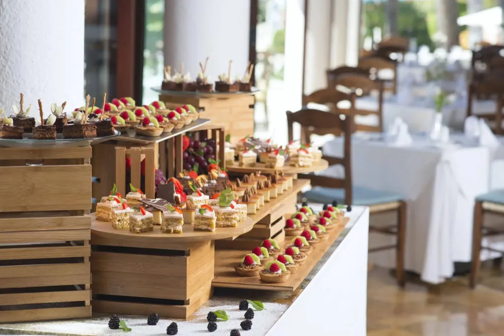Présentation de pâtisseries et de fruits frais sur un buffet.