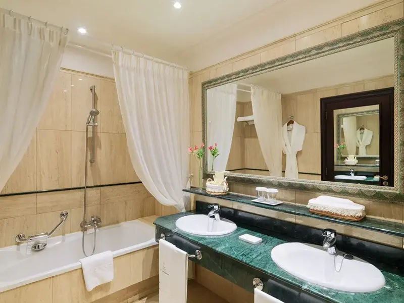 Une salle de bain lumineuse avec baignoire et deux vasques.