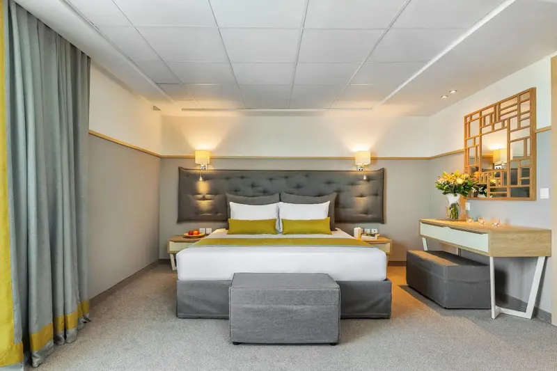 Une chambre lumineuse avec un grand lit et un mobilier moderne.