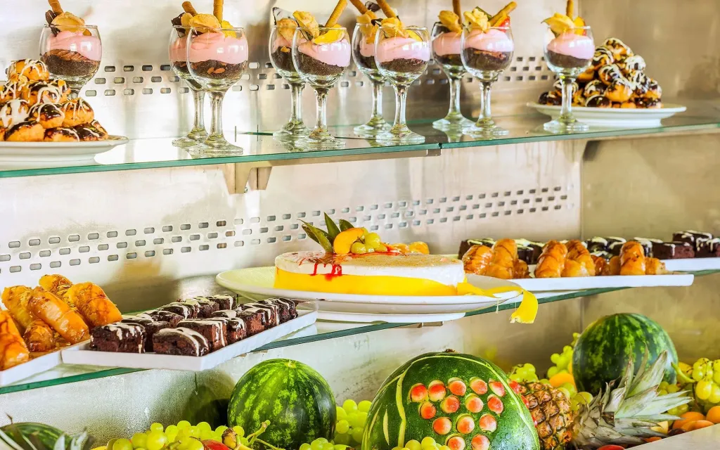 Présentation de desserts variés et de fruits frais sur un buffet.