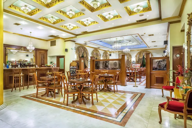 Une salle lumineuse avec un bar et des tables à manger.