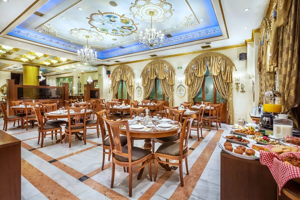 Une salle lumineuse avec des tables dressées pour le repas.