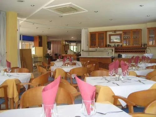 Une salle lumineuse avec des tables dressées pour le service.