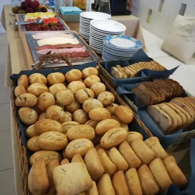 Présentation de charcuterie, de fromages et de pains variés sur un buffet.