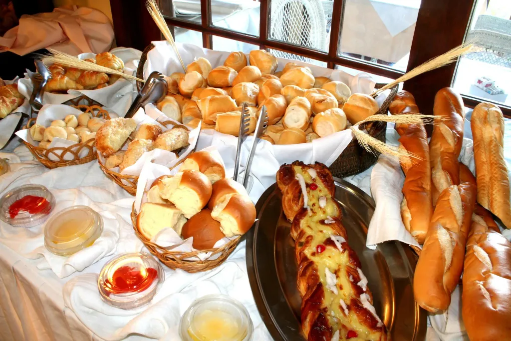 Un buffet propose une variété de pains et de viennoiseries.