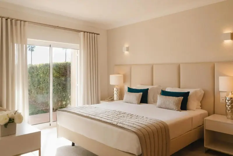 Une chambre lumineuse avec un grand lit et un accès à une terrasse.