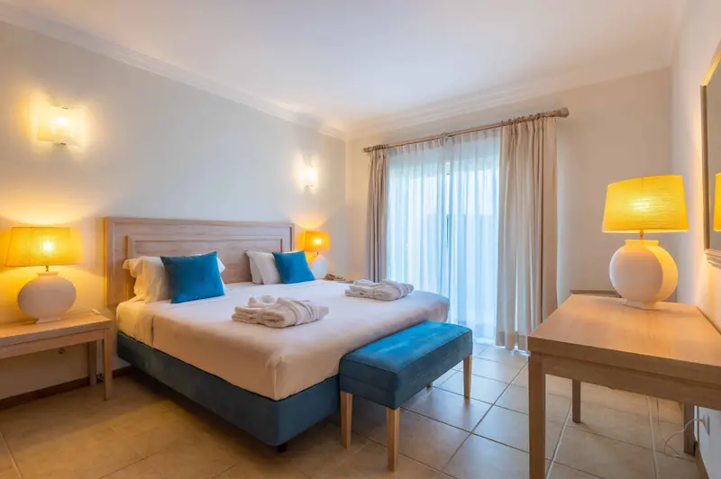 Une chambre lumineuse avec un grand lit et un accès à une terrasse.