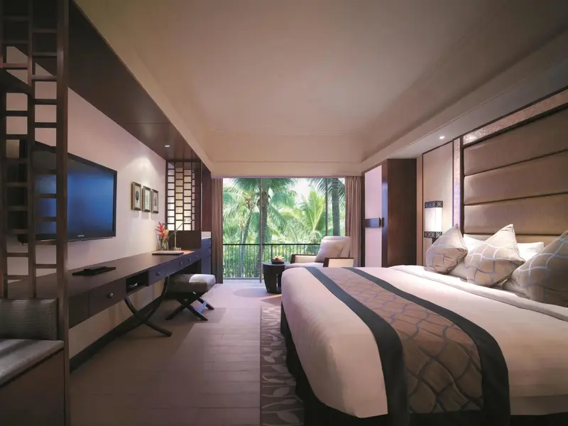 Une chambre spacieuse avec un grand lit et une vue sur la végétation.