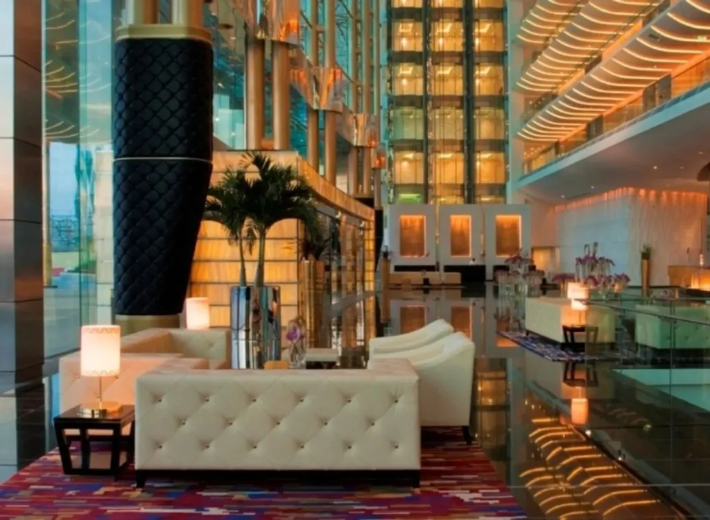 Un espace de détente lumineux avec des canapés blancs et des éclairages modernes.