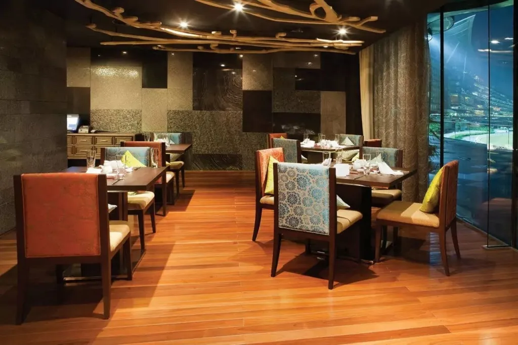 Une salle de restaurant lumineuse avec des tables dressées et une vue sur un récif corallien.