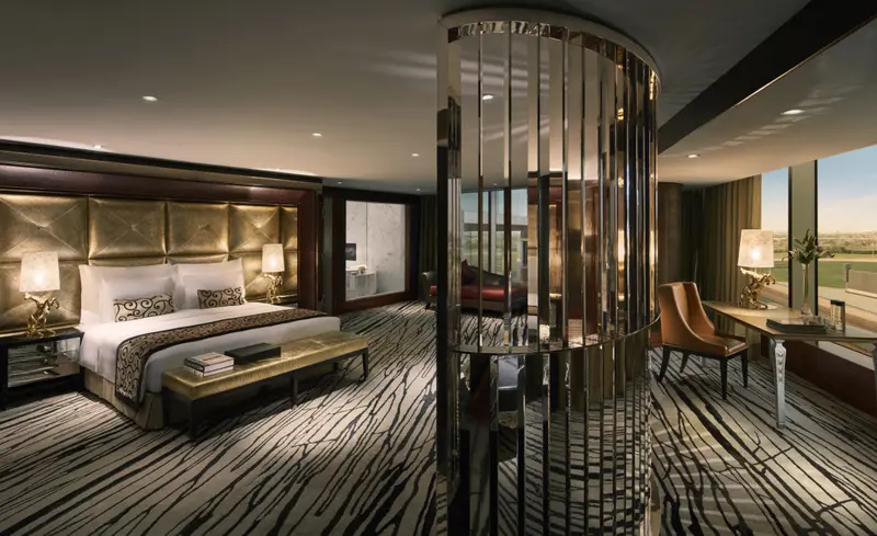 Une chambre spacieuse avec un grand lit et un bureau près d'une fenêtre.