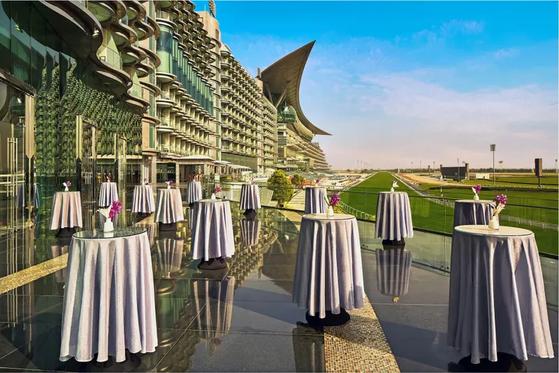 Terrasse aménagée avec tables et chaises devant un bâtiment moderne.