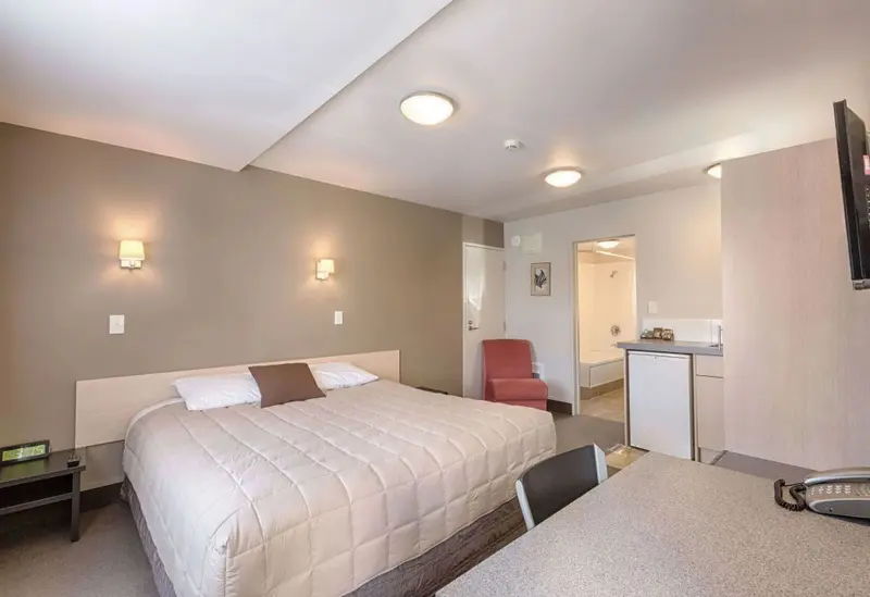Une chambre lumineuse avec un lit et un coin repas.