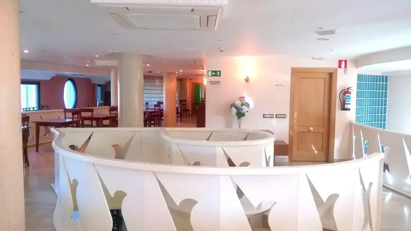 Espace intérieur lumineux avec des tables et des fauteuils blancs.