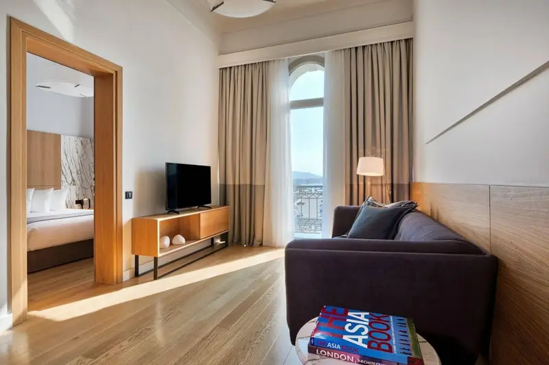 Un salon lumineux avec canapé et télévision donne sur une vue dégagée.