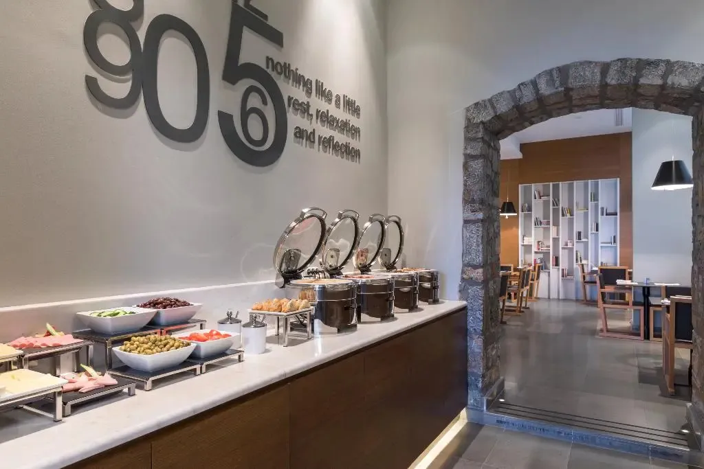 Un buffet propose une variété de plats et de salades dans un espace lumineux.