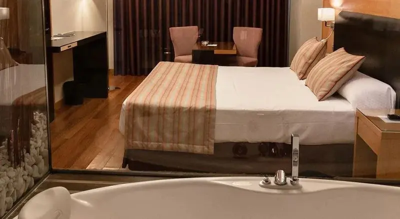 Une chambre avec un grand lit et un espace repas.