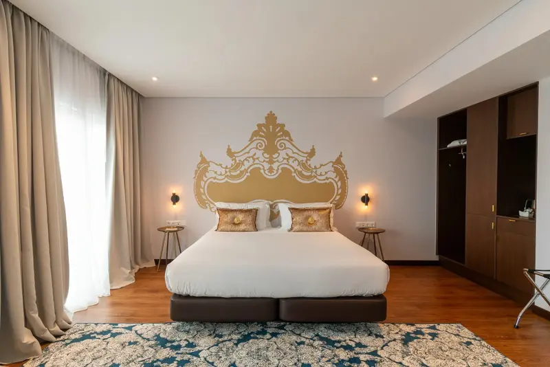 Une chambre lumineuse avec un grand lit et une décoration murale élaborée.