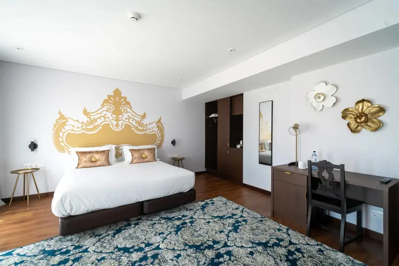Une chambre lumineuse avec un grand lit et un bureau.