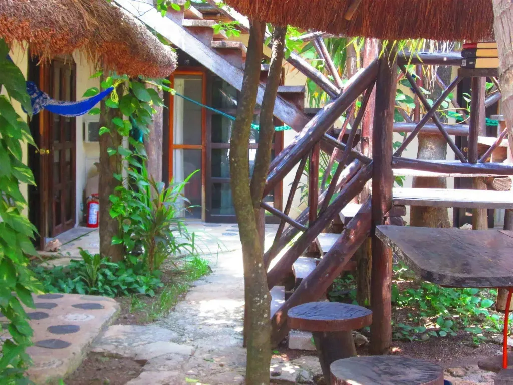 Un espace extérieur ombragé avec des tables et des bancs en bois.