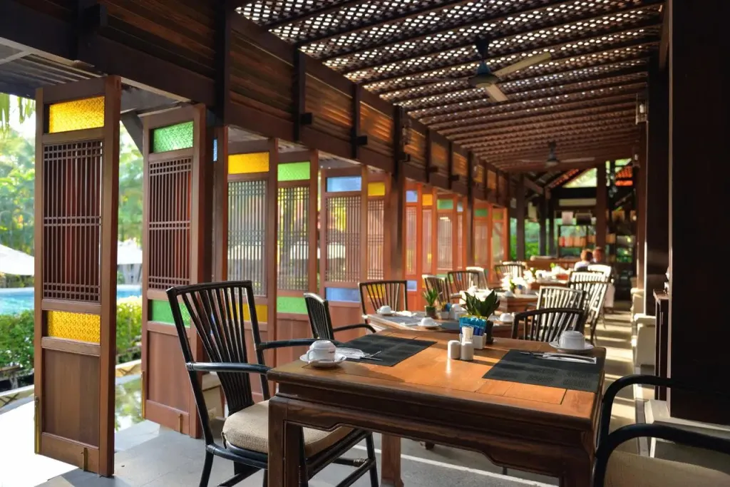 Une salle à manger lumineuse avec des tables dressées et un décor coloré.
