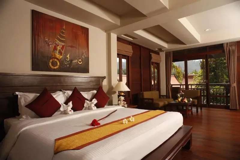 Une chambre spacieuse avec un grand lit et un coin salon.