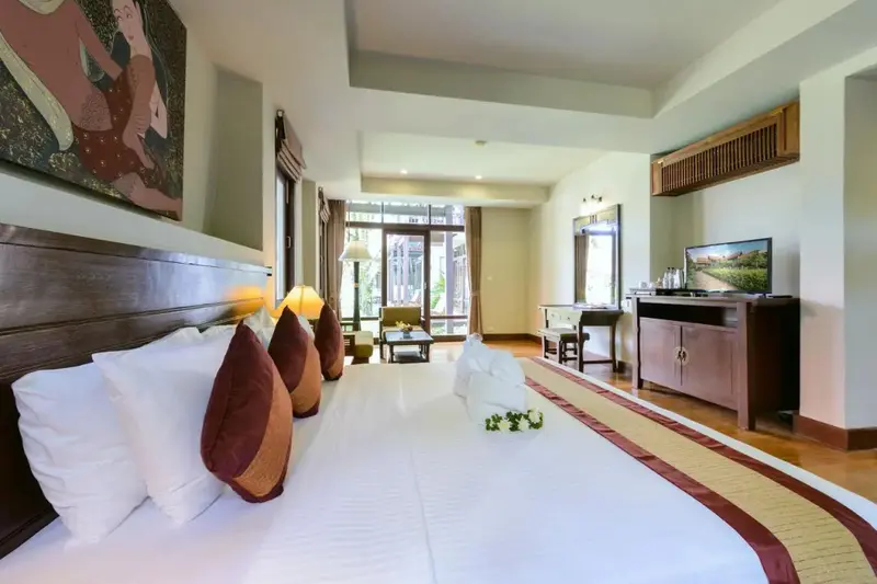 Une chambre lumineuse avec un grand lit et un espace détente.