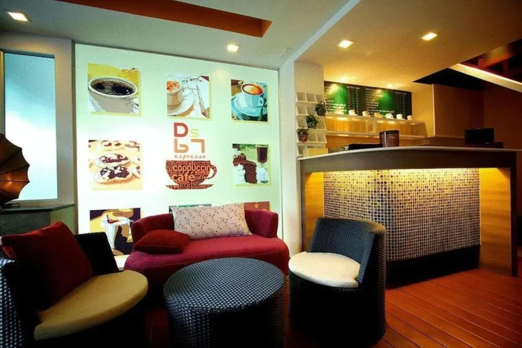 Un espace de détente avec canapés et fauteuils est décoré d'illustrations de boissons chaudes et de pâtisseries.