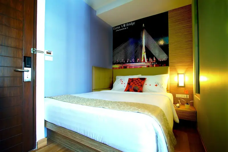 Une chambre d'hôtel moderne avec un lit fait et une décoration murale.