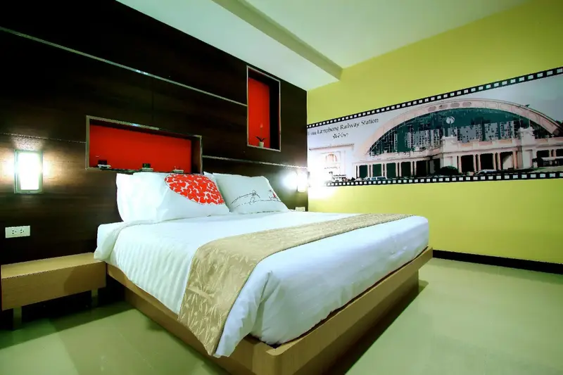 Une chambre lumineuse avec un grand lit et un décor mural.