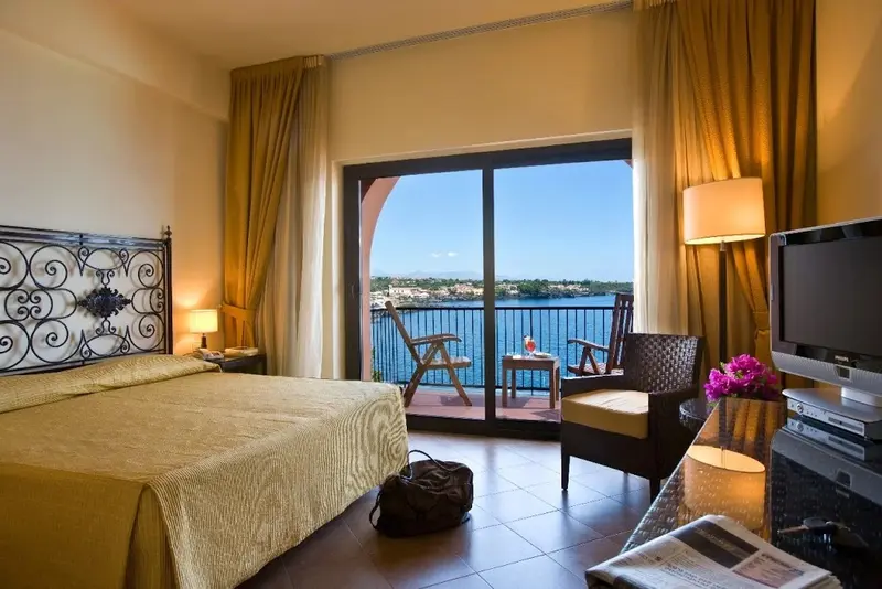 Une chambre lumineuse donne sur une terrasse avec vue sur la mer.