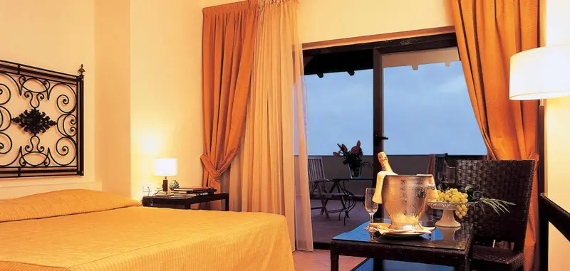 Une chambre lumineuse s'ouvre sur une terrasse avec vue sur la mer.