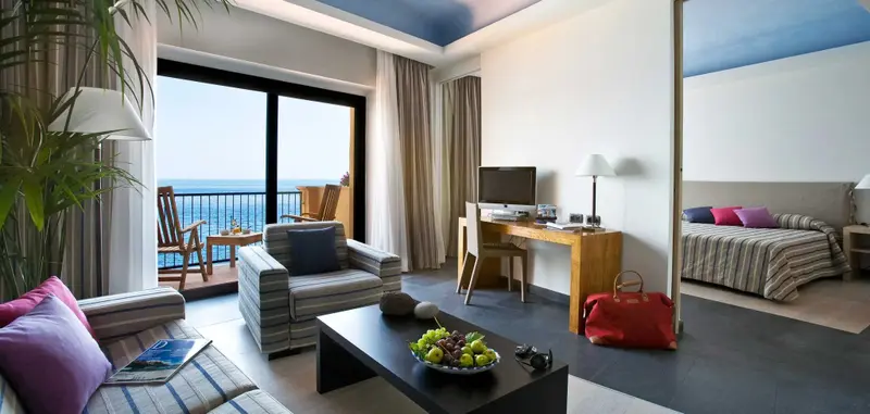 Espace de vie lumineux avec vue sur la mer depuis un balcon.