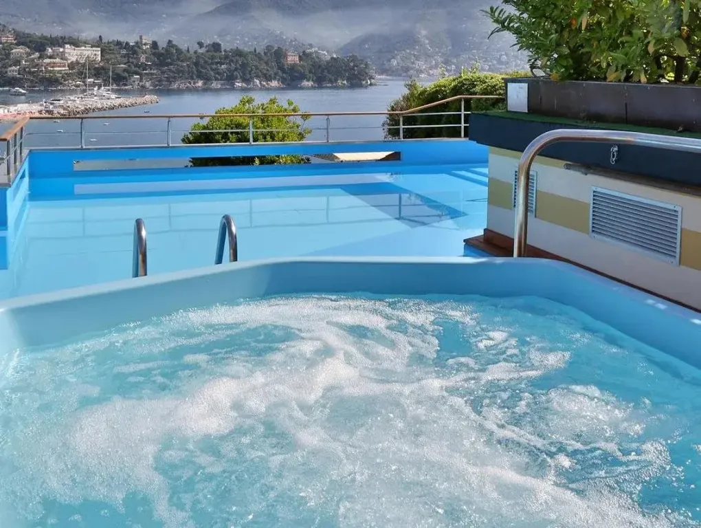 Une piscine avec des jets d'eau et une vue sur la mer.