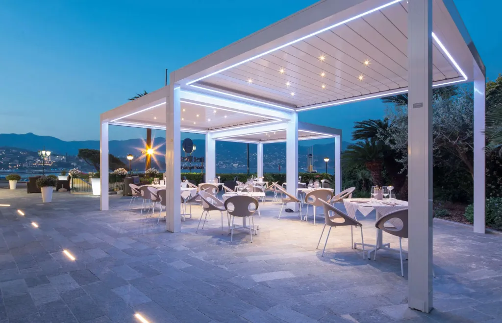 Terrasse lumineuse avec tables dressées pour un repas en extérieur.