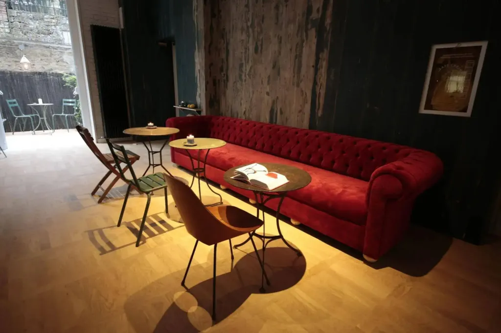 Un canapé rouge et des tables basses dans un espace de détente intérieur.