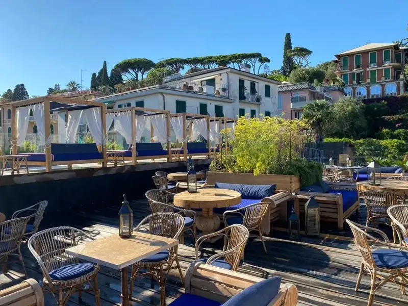 Terrasse aménagée avec des tables et des canapés en osier.